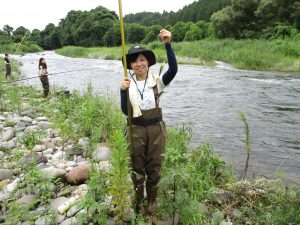 つりあげたあゆを片手に笑う参加者